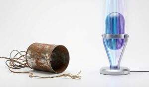 프리미어 프로 AI 적용 전과 후의 오디오 품질 대비. 왼쪽은 녹슨 깡통 전화기로 나쁜 음질을 상징하고, 오른쪽은 미래지향적인 빛나는 마이크로 고품질 AI 오디오를 상징하는 제품 사진.